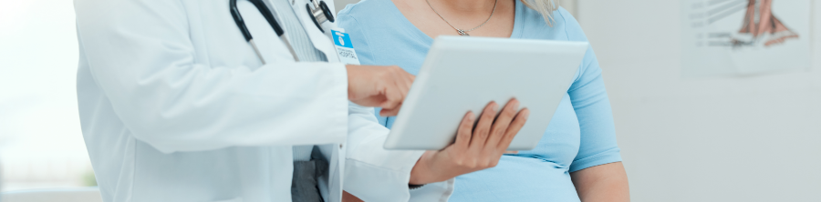 Un médecin présente de l’information à une patiente enceinte sur une tablette électronique
