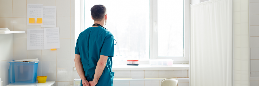 Physician in thought, looking out a window.