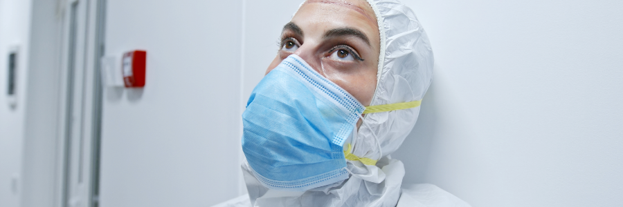 A tired-looking doctor wearing full personal protective equipment