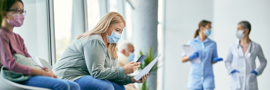 Une femme consultant son téléphone dans la salle d’attente d’une clinique