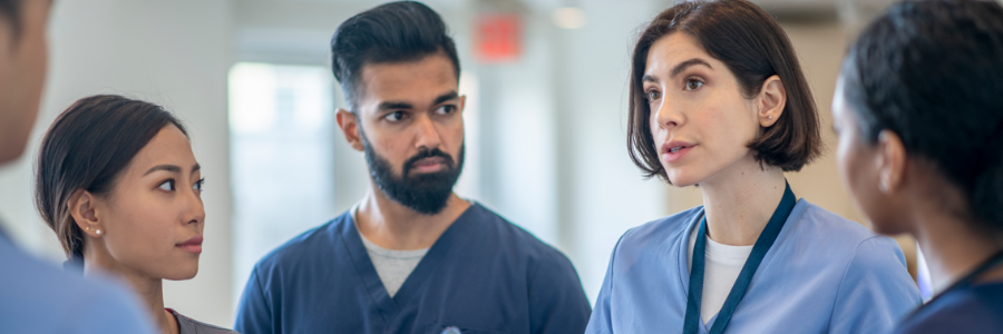 Five young doctors having a standing meeting