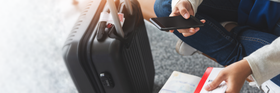 A traveller with suitcase and phone