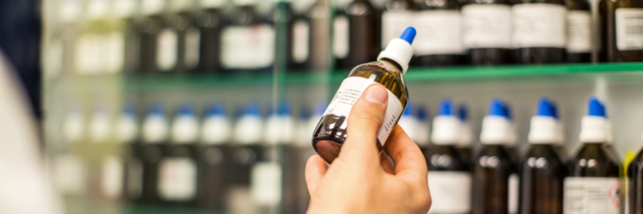 A physician examining a bottle of homeopathic medicine