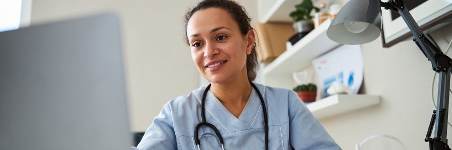 Une médecin travaille sur un ordinateur portable