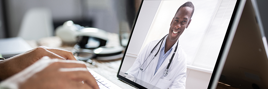 Male doctor shown on a laptop screen talking in a videoconference