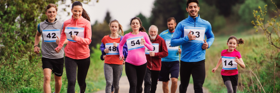 Group of multi-generational people running in a race competition in nature.