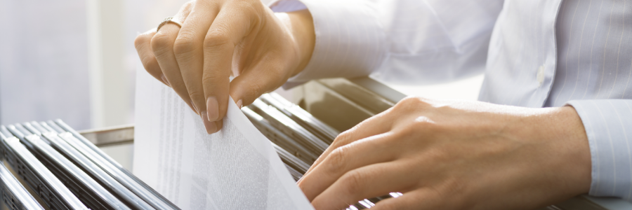 Hands reaching into a filing cabinet.