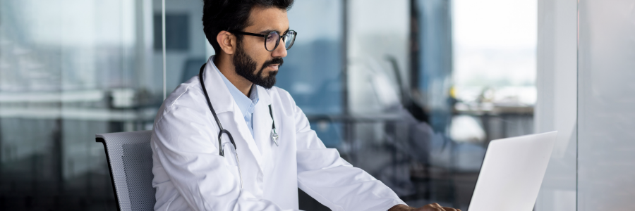 Physician working on laptop in office