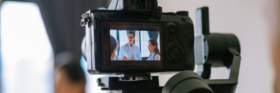 Camera in a tripod recording a conversation between doctors and a patient. 