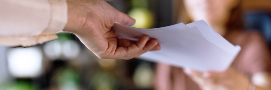 A woman handing a document to another person