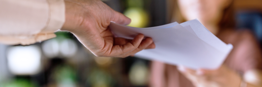 Une femme qui tend un document à une autre personne