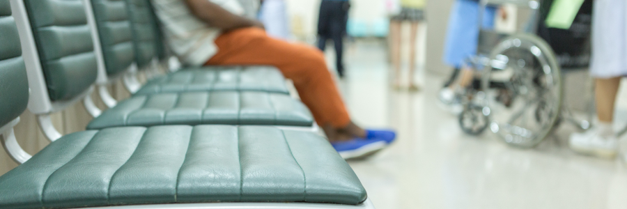 Emergency department waiting area with chairs and patients