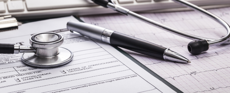 Medical documents on a table with a stethoscope.