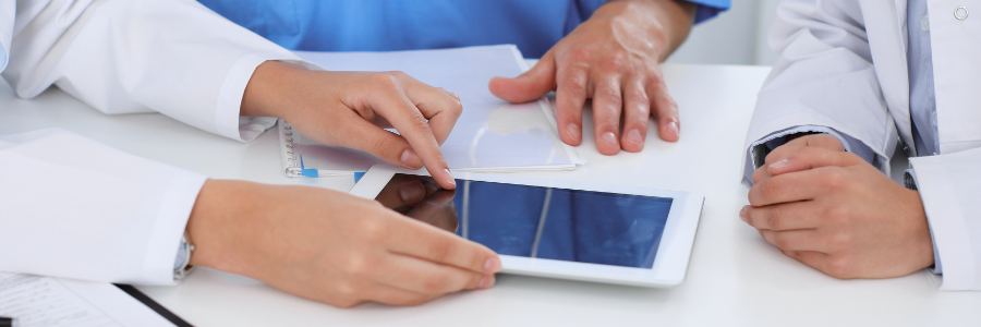 Physicians reviewing an Electronic Medical Record on a tablet