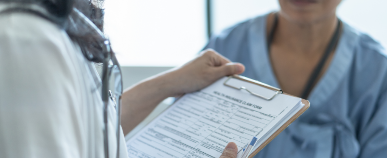 Female physician reviewing medical records with a patient.