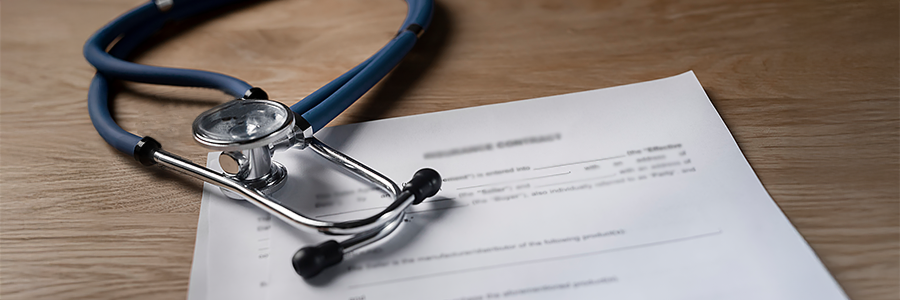 A stethoscope resting on top of a medical document on a desk.