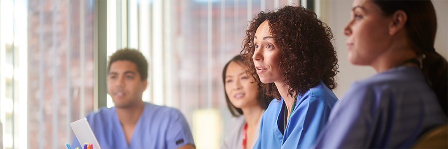 A small group of healthcare professionals seated at a conference,  engaged in discussion