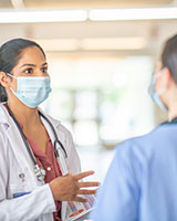 Une médecin discute avec un membre du personnel infirmier.