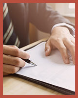 Homme en complet-cravate remplissant un document