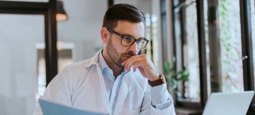 Médecin de sexe masculin lisant un rapport médical