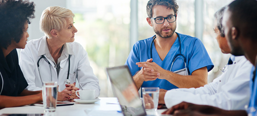 Male physician speaking at a meeting with his peers.