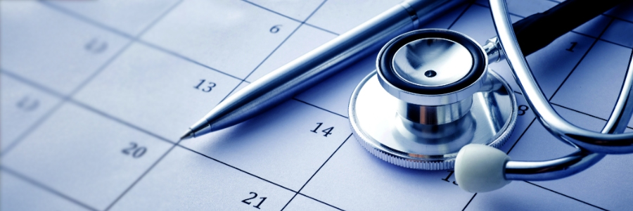 Un stéthoscope et un stylo posés sur un calendrier.