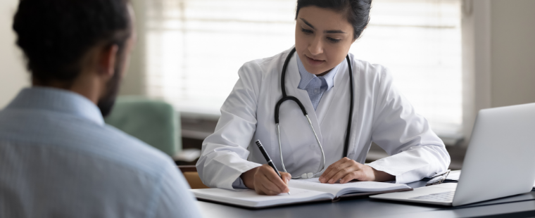 Une médecin prend des notes durant une consultation avec un patient.