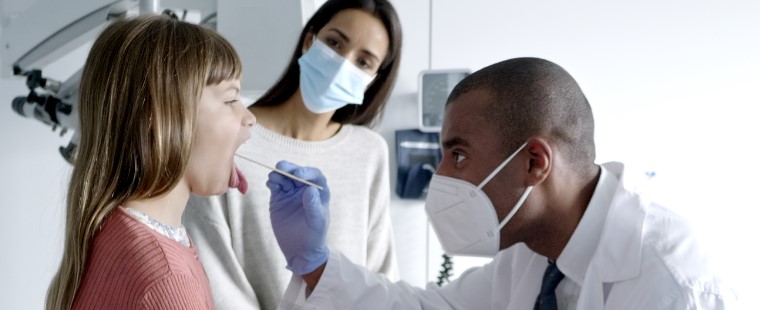 Male doctor examining a young female patient.