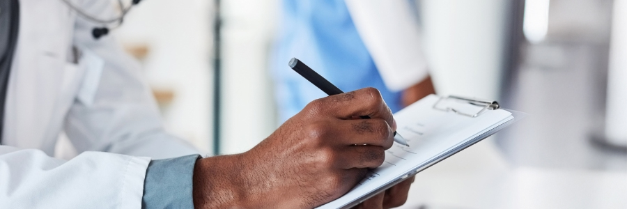 Physician writing on a clipboard.
