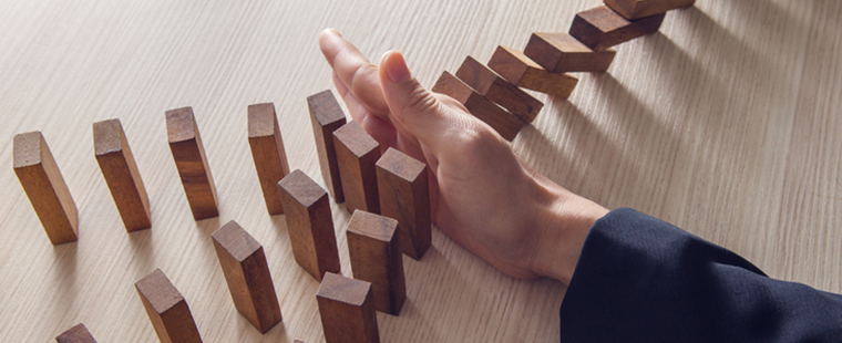 Hand preventing falling wooden blocks from knocking down other formation of wooden blocks.