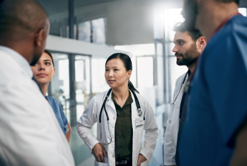 Healthcare professionals engaging in a team debrief huddle.