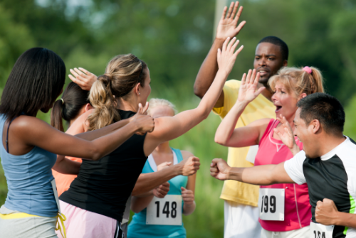 Group of runners high-fiving each other.