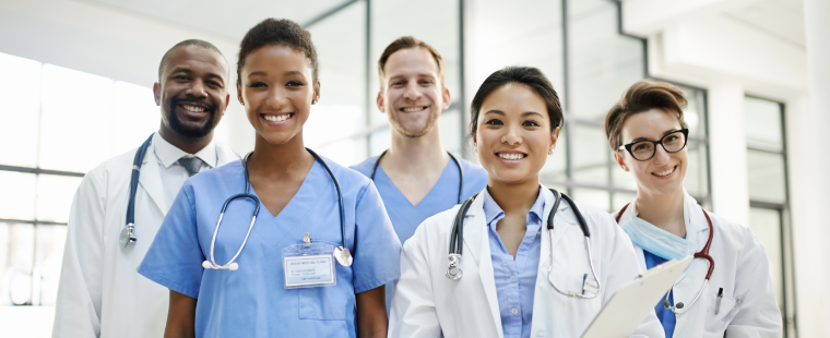 Group of smiling young physicians facing the viewer.