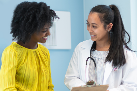 A physician consults with her patient