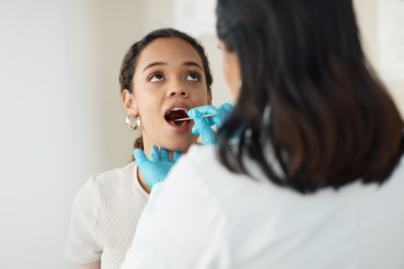 A physician examining a patient’s throat.