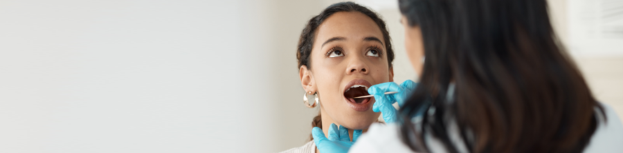 A physician examining a patient’s throat.