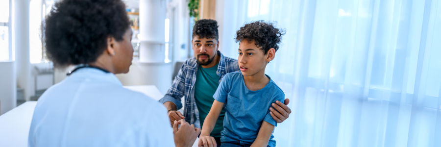 Une médecin en consultation avec un garçon et son père